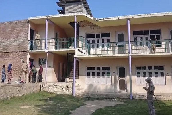 Students standing outside a locked school building during rain